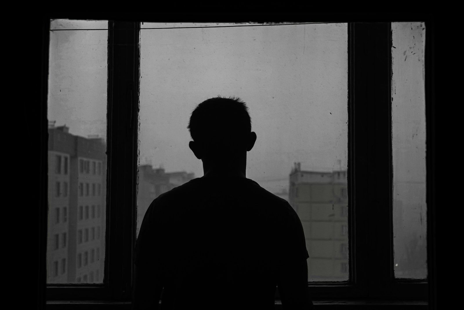 silhouette of man standing near window